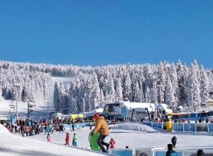 a man riding a snowboard on a snow covered slope at Woodside Kopaonik & SPA by Slopeview in Kopaonik