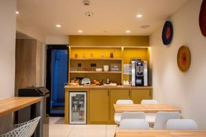 a kitchen with yellow cabinets and a table and chairs at HOTEL AMBASSADEUR in Lille