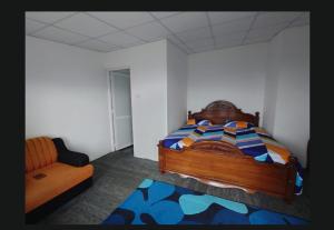 a bedroom with a bed and a chair and a couch at Agape center in Haputale