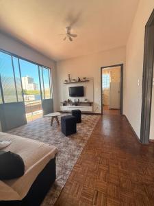 a large living room with a bed and a television at Casa do Mauro in Foz do Iguaçu