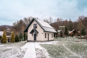 a small white house with a black roof at Domek Wierzbowa 5 in Brenna