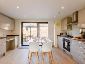 a kitchen with a table and two white chairs at 2 Bed in Alcester oc-88397 in Coughton +10 photos
