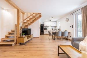 a living room with a staircase and a dining room at Domek Wierzbowa 5 in Brenna