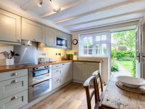 a kitchen with white cabinets and a table and a window at 2 Bed in Kelling Holt oc-76755 in Kelling +7 photos