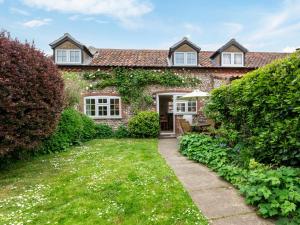 a stone house with a pathway leading to the front door at 2 Bed in Kelling Holt oc-76755 in Kelling