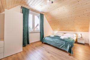 a bedroom with a bed and a wooden ceiling at Domek Wierzbowa 5 in Brenna