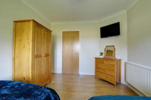 a bedroom with a bed and a dresser and a television at 2 Bed in Ingworth oc-1731 in Ingworth