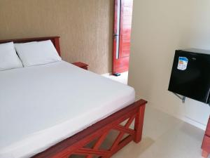 a bed in a room with a tv and a bed sidx sidx sidx at Pousada Tropical dos Corais in Cabo de Santo Agostinho
