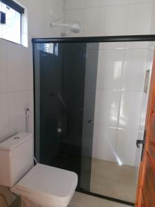 a bathroom with a toilet and a glass shower at Pousada Tropical dos Corais in Cabo de Santo Agostinho +10 photos