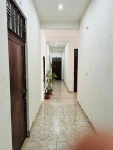 an empty hallway with a door and plants in it at BNT BOYs HOSTEL in Lucknow