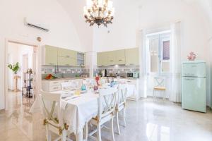 a kitchen with a table with chairs and a chandelier at Dimora 1890 in Parabita