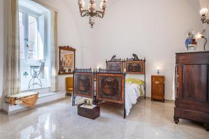 a bedroom with a bed and a dresser and a window at Dimora 1890 in Parabita +8 photos