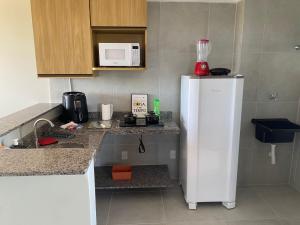 a kitchen with a white refrigerator and a microwave at Residencial T&D V AP 501 - À 5min do Centro e Faculdades in Mossoró +23 photos