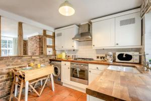 a kitchen with white cabinets and a wooden table at 2 Bed in Beccles oc-d33611 in Beccles