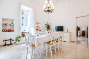 a white dining room with a table and chairs at Dimora 1890 in Parabita