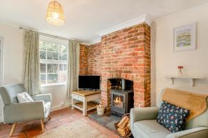 a living room with a brick wall and a fireplace at 2 Bed in Beccles oc-d33611 in Beccles