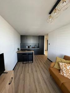a living room with a couch and a kitchen at CityView Tychy in Tychy