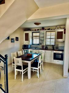 a kitchen with a table and chairs in it at Къща за гости Геша Форест 3 in Dryanovo