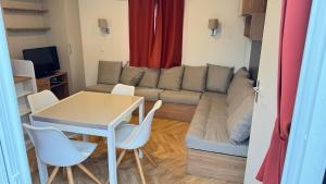 a living room with a couch and a table and chairs at Mobil home 148 in Pont-Aven