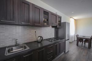 a kitchen with wooden cabinets and a sink and a refrigerator at Sevan Up In in Aghk'ilisa