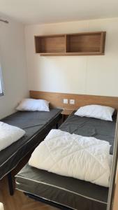 two beds sitting in a room with at Mobil home 148 in Pont-Aven +11 photos