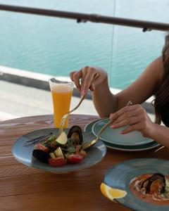 a woman sitting at a table with a plate of food at Sevan Up In in Aghk'ilisa +13 photos