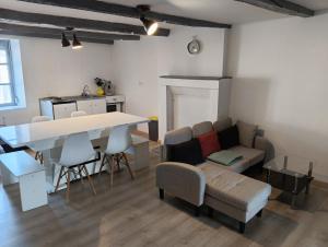 a living room with a table and a couch at Hébergements Sylvain in Neuilly-lʼÉvêque