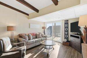 a living room with a couch and a tv at Lakin it Easy Condo for 2 in Kimberling City