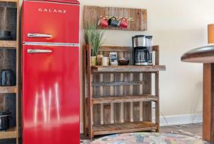 a red refrigerator in a kitchen next to a shelf at Lakin it Easy Condo for 2 in Kimberling City
