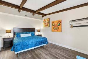 a bedroom with a bed with a blue comforter at Lakin it Easy Condo for 2 in Kimberling City +22 photos