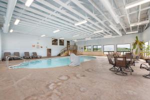 a pool in a large room with chairs and a table at Lakin it Easy Condo for 2 in Kimberling City