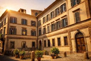 a large building with potted plants in front of it at VesConte Residenza D'epoca dal 1533 in Bolsena