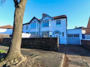 a large white house with a tree in front of it at Broadgreen in Liverpool