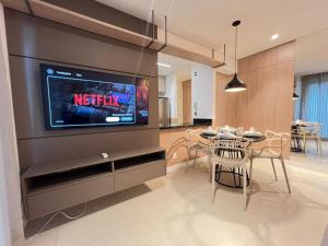 a living room with a television and a table with chairs at LK Savassi 7 in Belo Horizonte
