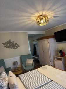 a bedroom with a bed and a chandelier at Pension Mien Fründt in Baabe