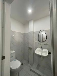 a bathroom with a toilet and a sink and a mirror at Tanauan Transient Casa Joe in Daraza +27 photos
