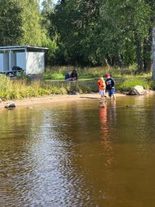 a man and a child walking in the water at Edsken Camping in Hofors