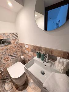 a bathroom with a toilet and a sink and a mirror at DIMORA MedioEvo in Orvieto