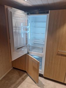 an empty refrigerator with its door open in a kitchen at Rustikale Wohnung auf dem Bauernhof in Malters +12 photos