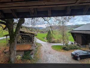 a car parked on a gravel road next to a house at Rustikale Wohnung auf dem Bauernhof in Malters