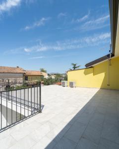 a patio with a yellow wall and a fence at Pantaleo Rooms in Santadi