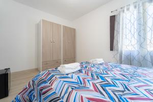 a bedroom with a large bed with a colorful blanket at Pantaleo Rooms in Santadi +8 photos
