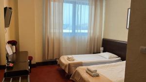 a hotel room with two beds and a window at Neptun in Legnica