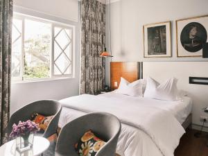 a hotel room with a bed and two chairs at Atemporal by Andean in Lima +37 photos
