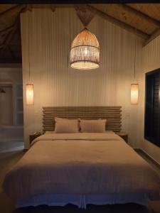 a bedroom with a large bed and a chandelier at Casa da Ponta in Fortim