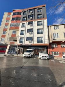 two cars parked in a parking lot in front of a building at Bediroğlu Airport Apart in Arnavutköy