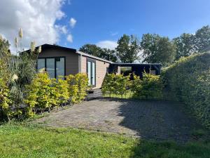 a house with a garden and a driveway at Chalet de Hofstee 118 in Nunspeet