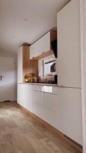 a kitchen with white cabinets and a counter top at Chalet de Hofstee 118 in Nunspeet