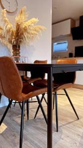 a dining room table with chairs and a vase of flowers at Chalet de Hofstee 118 in Nunspeet