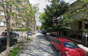 a red car parked on the side of a street at Damyanov residence in Pazardzhik